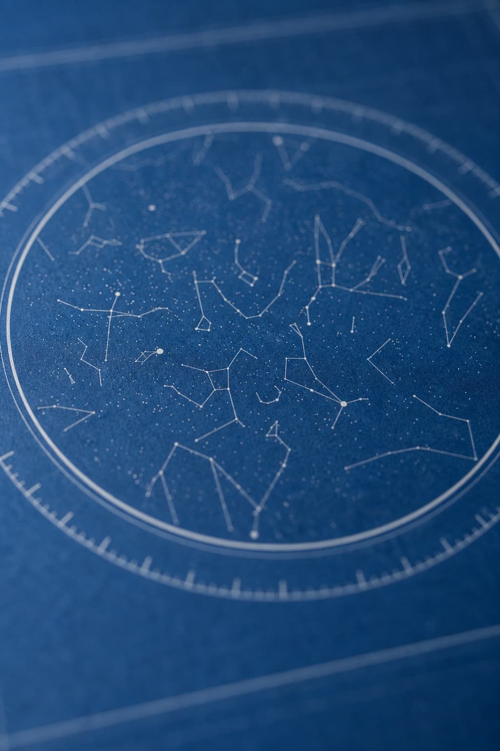 A close-up of a printed star map showing fine star points and a finely marked bearing ring.