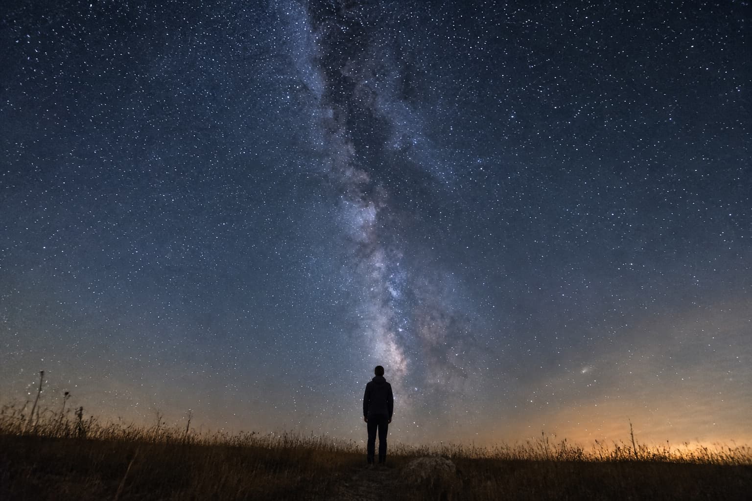A silhouette under a deep starfield